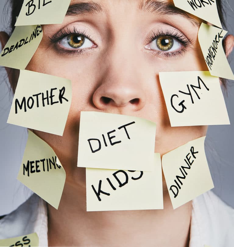 Exhausted woman covered in sticky-note chores such as "mother," "deadlines," and "meeting," struggling to cope—highlighting the need to hire a virtual assistant for support.
